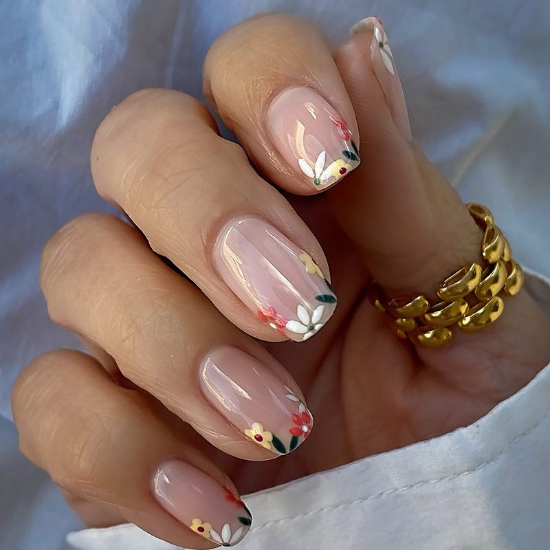 close-up of a simple sun nail design on short nails in bright yellow and white
