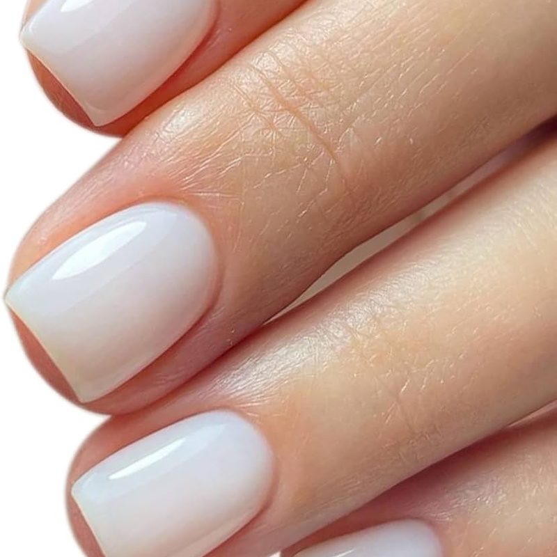 close-up of hand with white base manicure highlighting elegant nail art