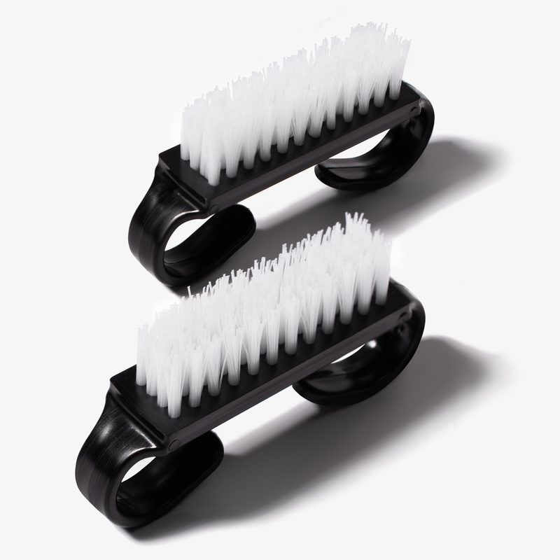 Hand applying cuticle oil to black nails for manicure care