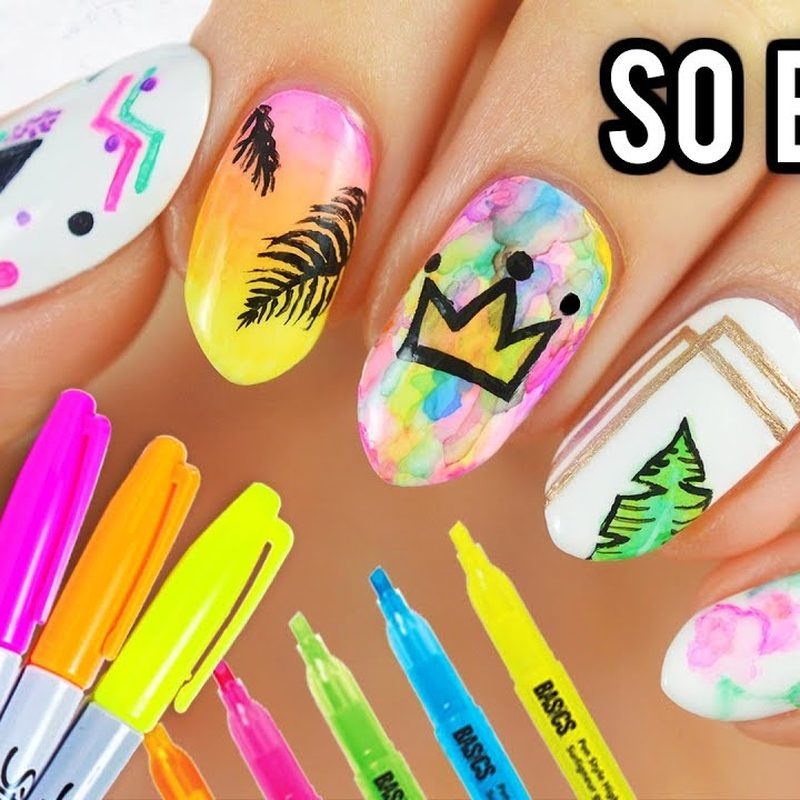 hand holding a nail art pen demonstrating technique