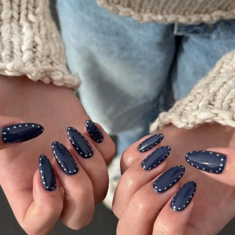 nail salon technician applying blue gel nails with artistic design