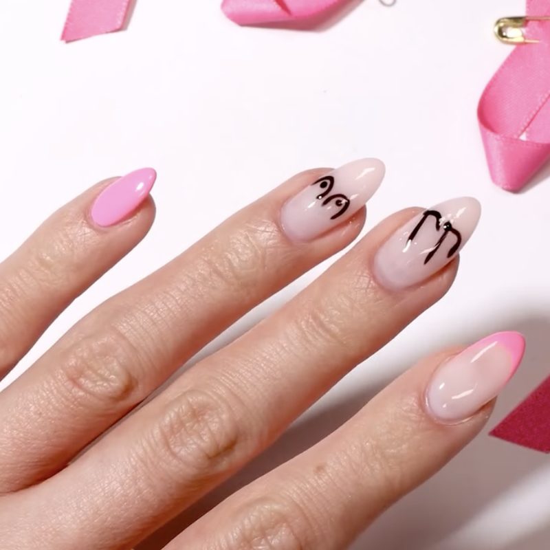 nail technician applying breast cancer awareness nail art in salon