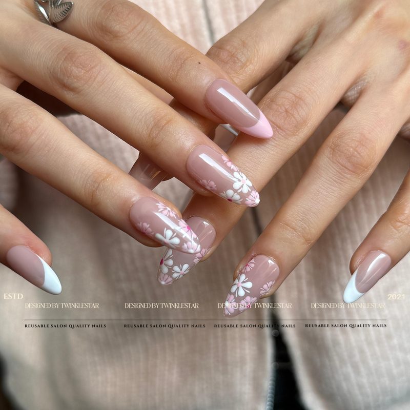 nail technician applying white nail polish with design in a salon
