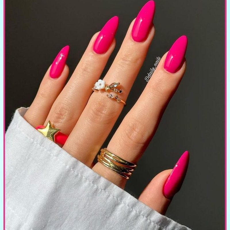 Trendy fuchsia pink nails with metallic gold accents and geometric patterns