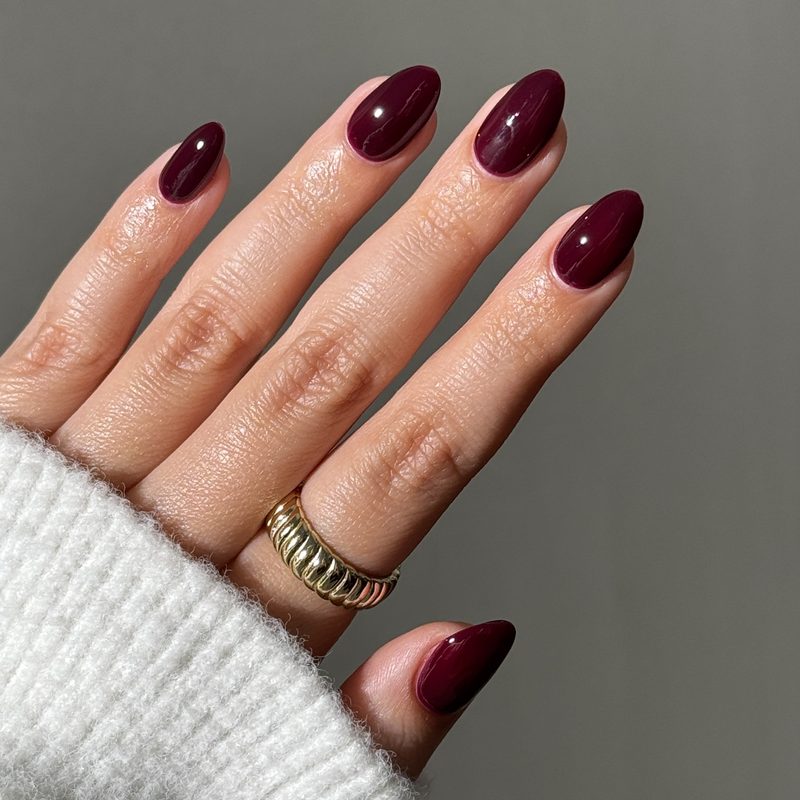Close-up of elegant nighttime nail design featuring deep jewel tones and shimmer