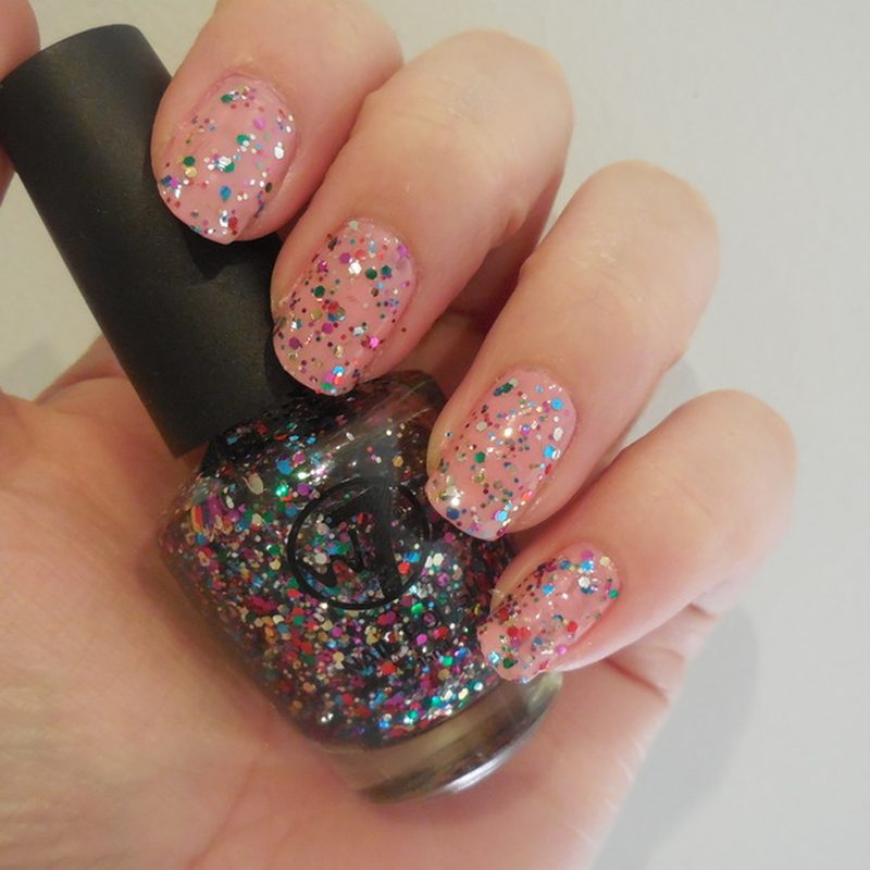 hands applying glitter nail polish with sponge for gradient effect