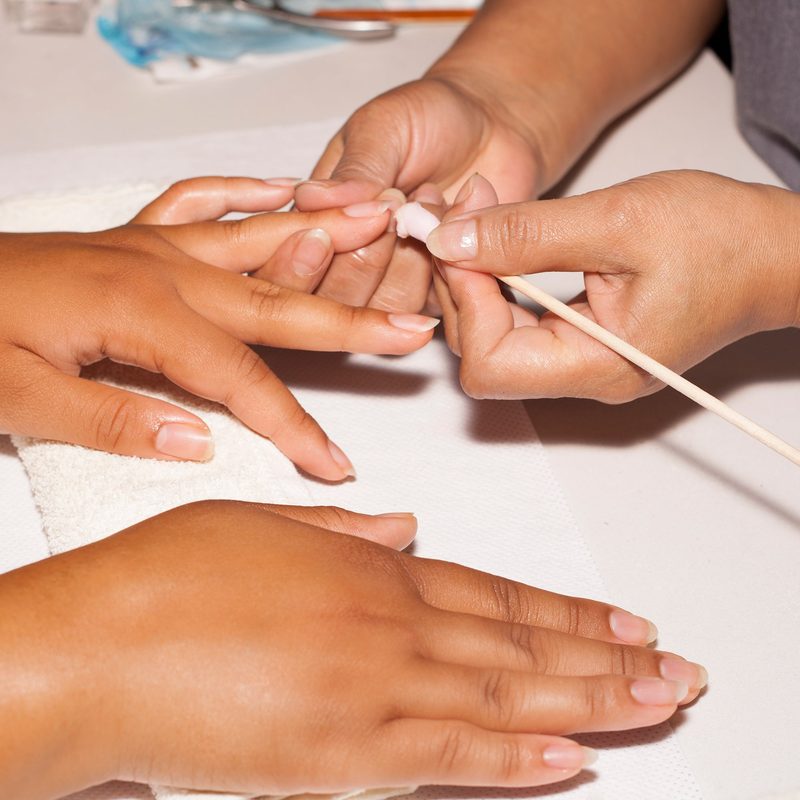 nail technician working on custom nail designs with premium materials