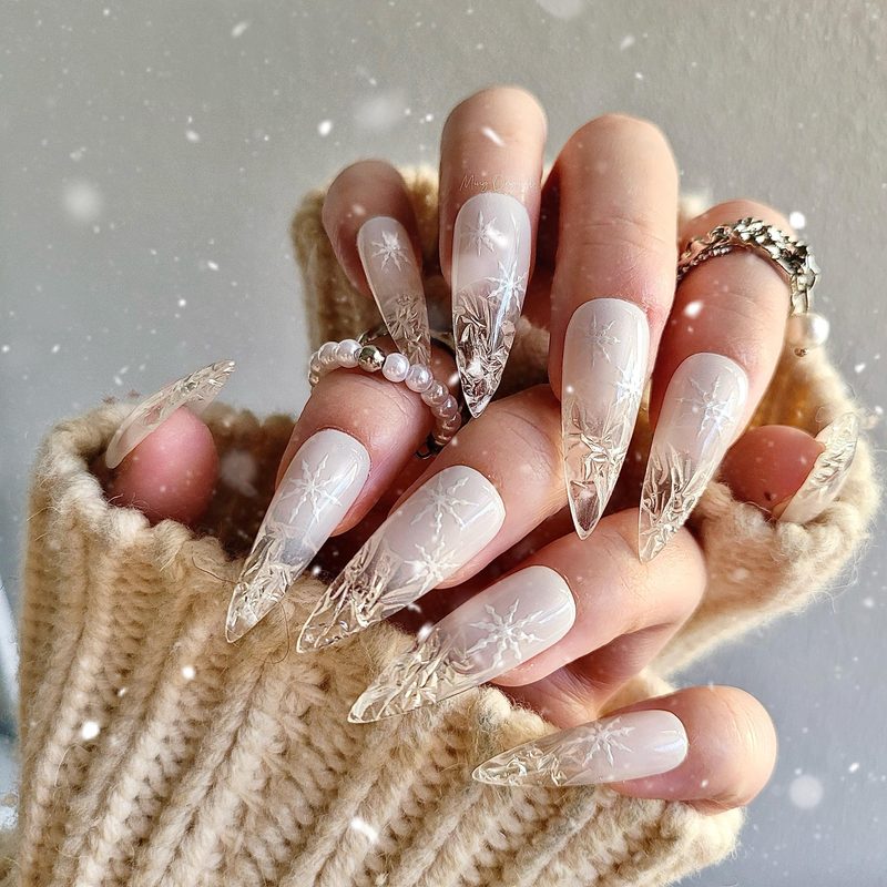 square nails with festive snowflake patterns and glitter accents